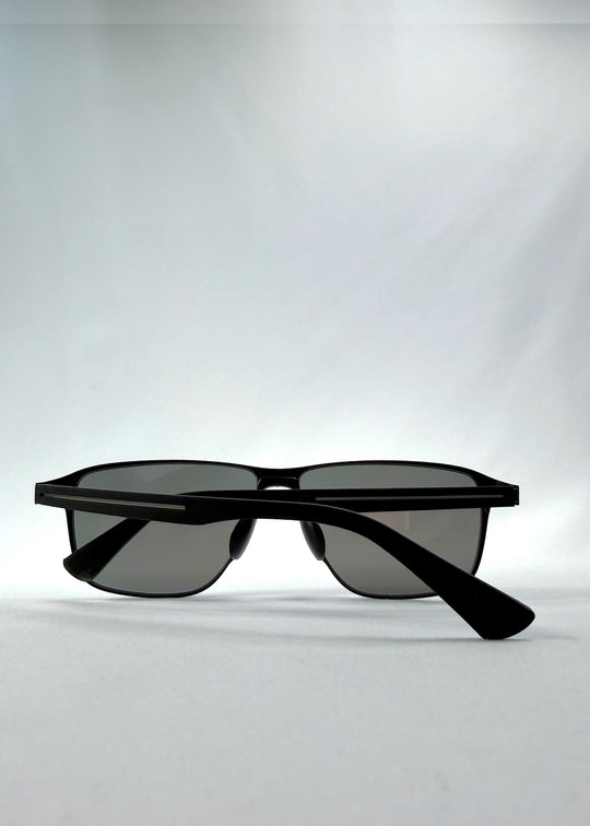 Folded view of Vector Line sunglasses in Mercury Shadow, featuring wide black metal frame and silver mirrored polarized lenses, showing the folded temples and frame profile.
