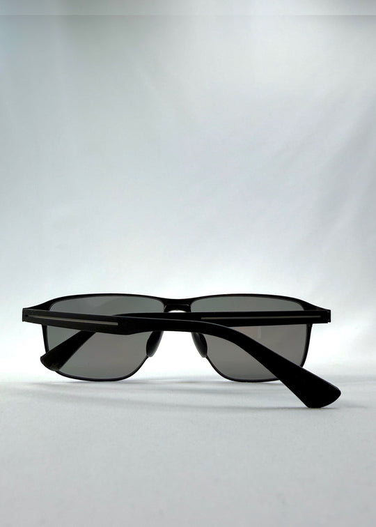 Folded view of Vector Line sunglasses in Mercury Shadow, featuring wide black metal frame and silver mirrored polarized lenses, showing the folded temples and frame profile. 
