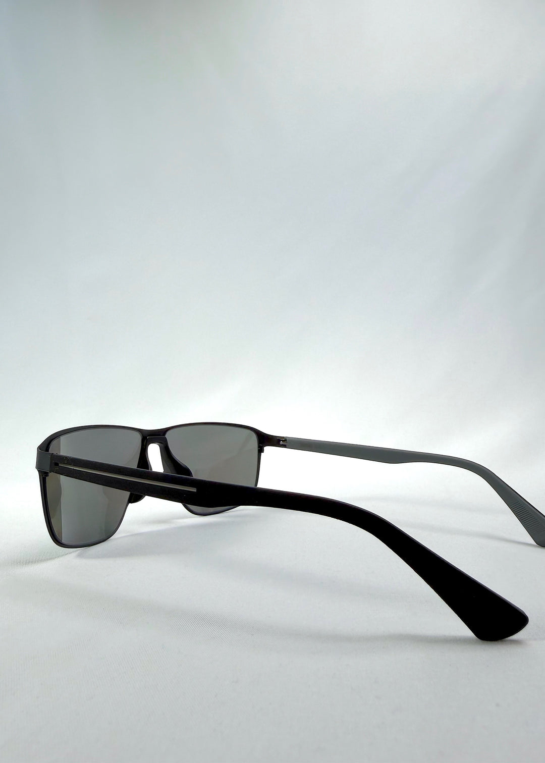 Side view of Vector Line sunglasses in Mercury Shadow, featuring wide black metal frame and silver mirrored polarized lenses, showing the lens shape and temple profile.
