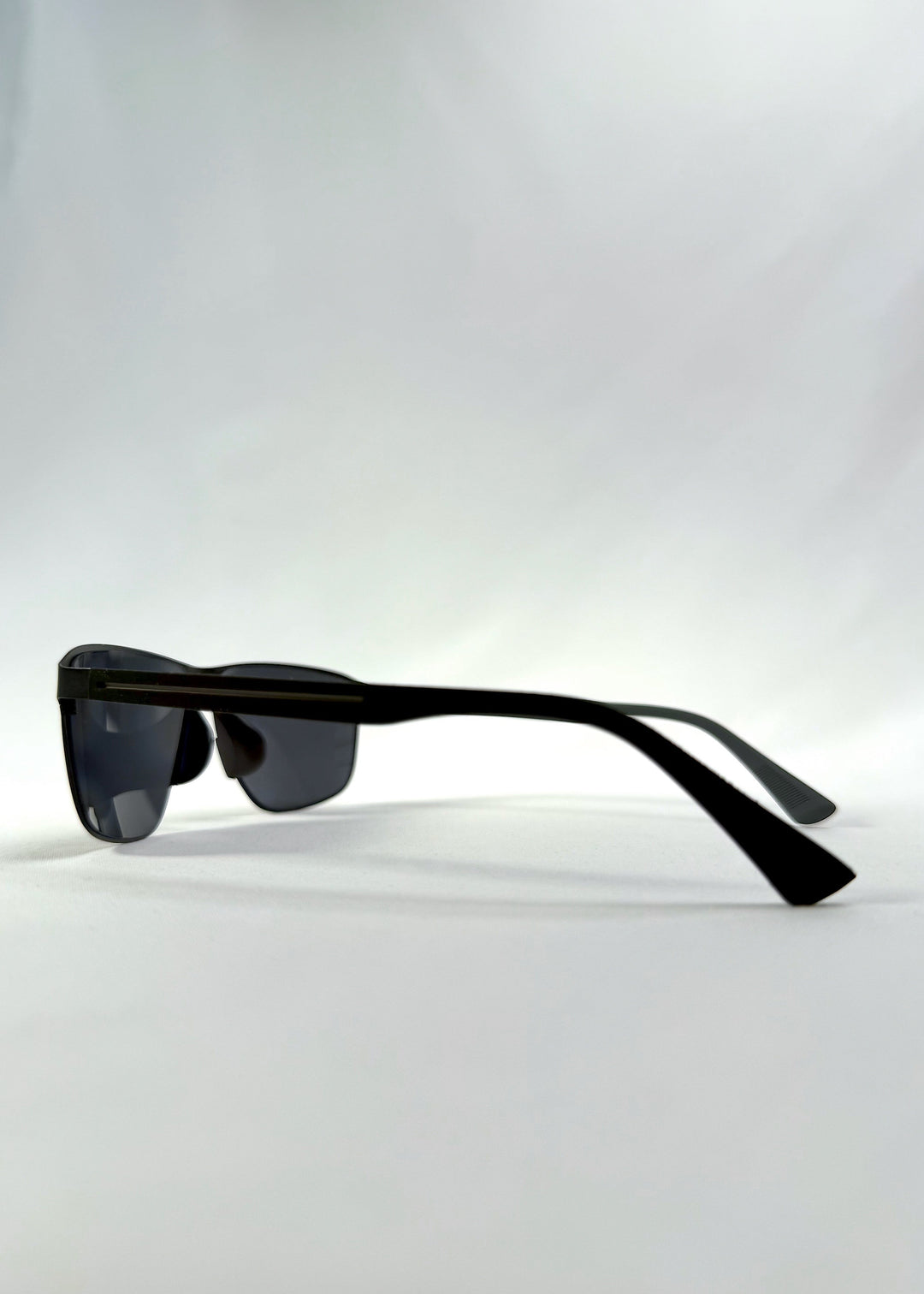 Side view of Vector Line sunglasses in Violet Graphite, featuring wide gunmetal frame and violet-grey polarized lenses, showing the lens shape and temple profile. 