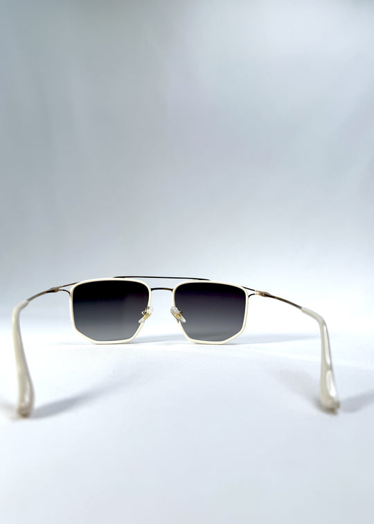 Back view of AZE Vela Trace sunglasses in Glacial Smoke, featuring a pale gold-tone rectangular frame and blue-gray gradient lenses, showing the inner frame and open temples.