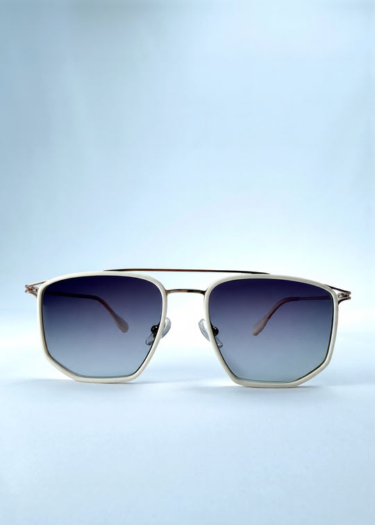 Front view of AZE Vela Trace sunglasses in Glacial Smoke, featuring a pale gold-tone rectangular frame and blue-gray gradient lenses, showing the full front silhouette.