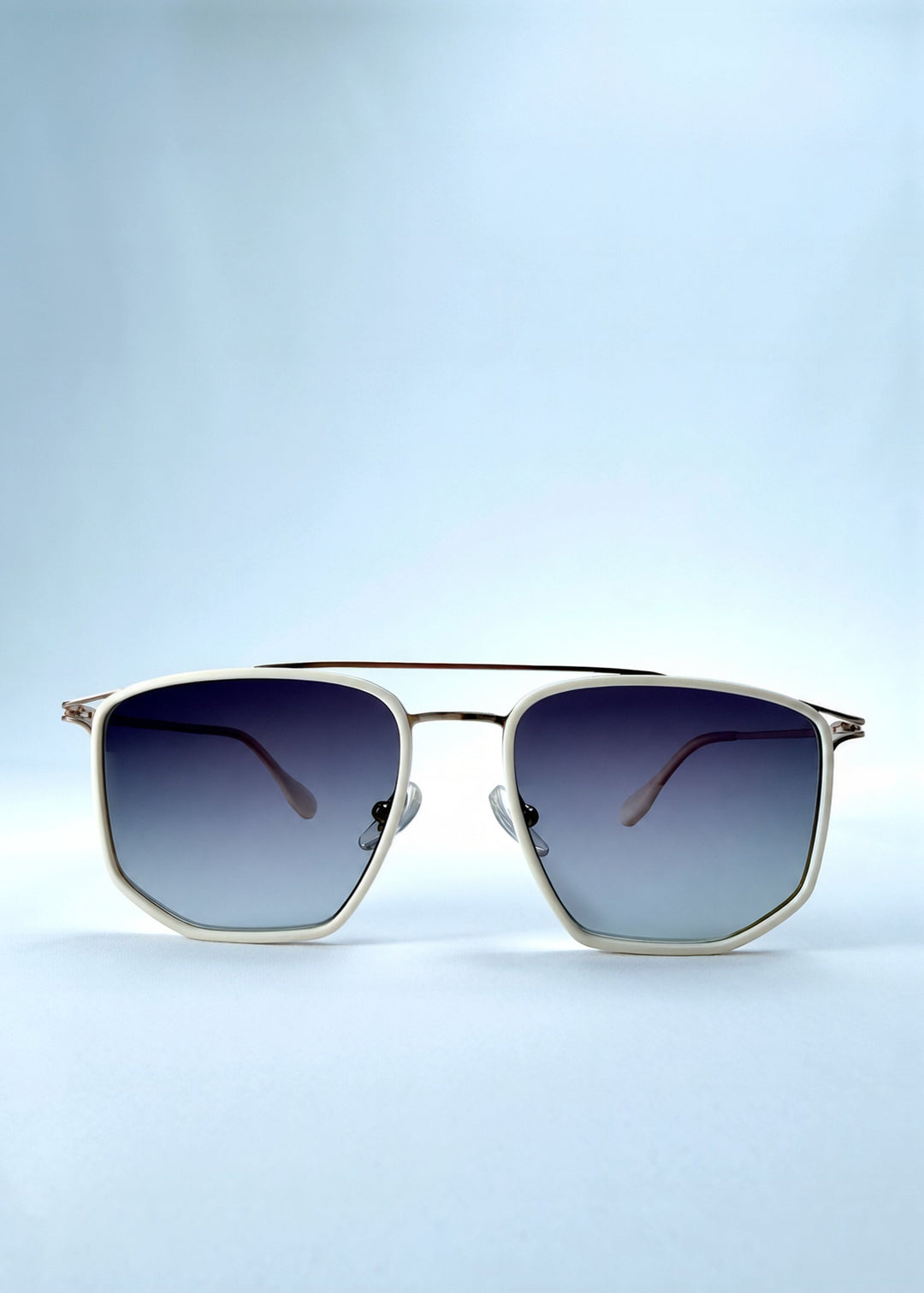 Front view of AZE Vela Trace sunglasses in Glacial Smoke, featuring a pale gold-tone rectangular frame and blue-gray gradient lenses, showing the full front silhouette. 