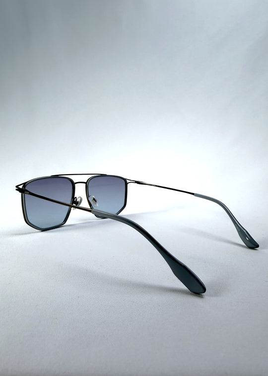 Back-angle view of AZE Vela Trace sunglasses in Midnight Blue, featuring a gray-blue rectangular frame and blue-gray gradient lenses, showing the rear frame structure and temple alignment.