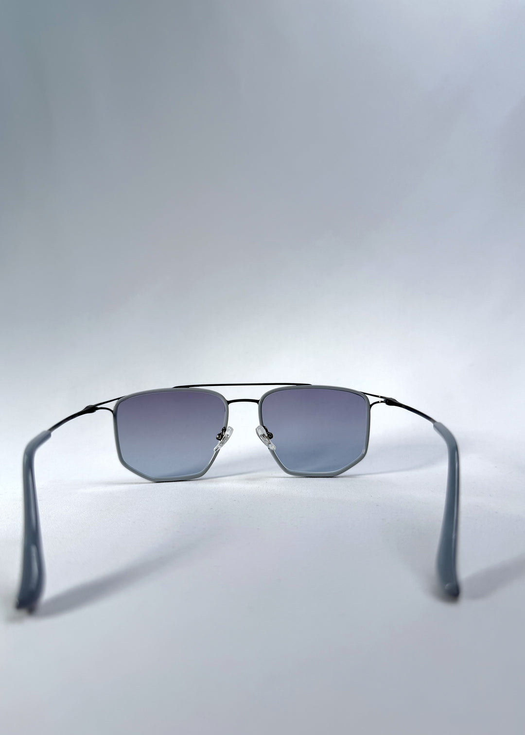 Back view of AZE Vela Trace sunglasses in Midnight Blue, featuring a gray-blue rectangular frame and blue-gray gradient lenses, showing the inner frame and open temples.