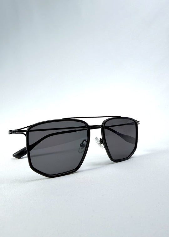 Folded view of AZE Vela Trace sunglasses in Obsidian Black, featuring a structured black rectangular frame and smoky gray lenses, showing the folded temples and frame profile.