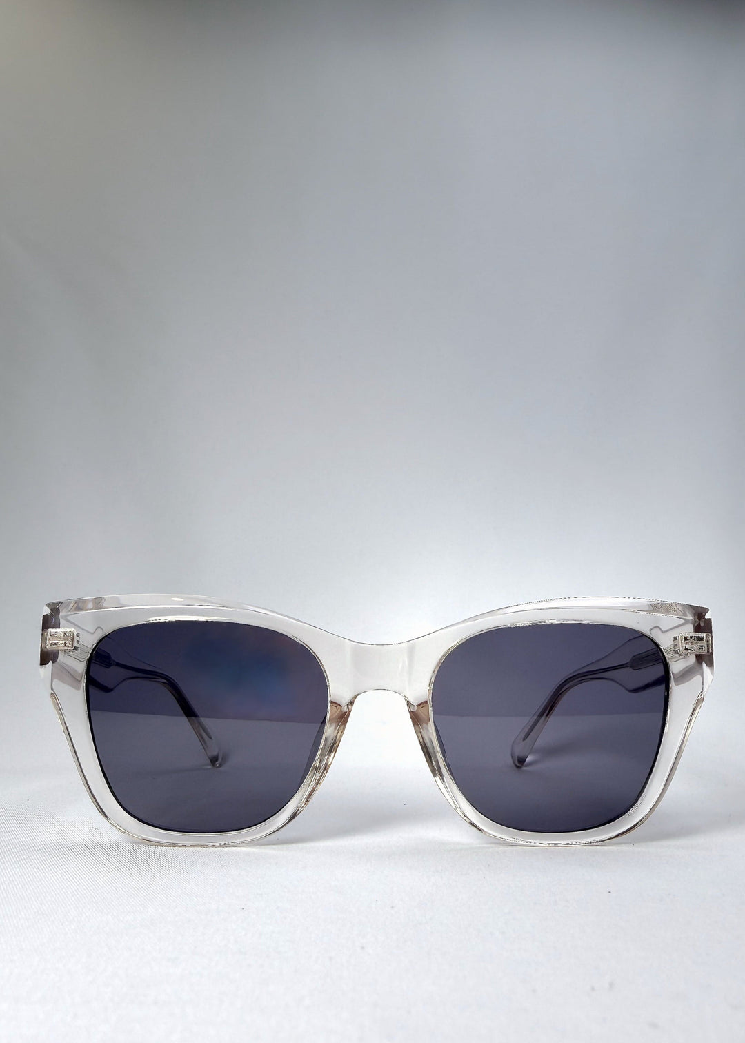 Front view of the Veyron sunglasses in Crystal Static, featuring a bold clear acetate frame with clean lines and slate-blue lenses.