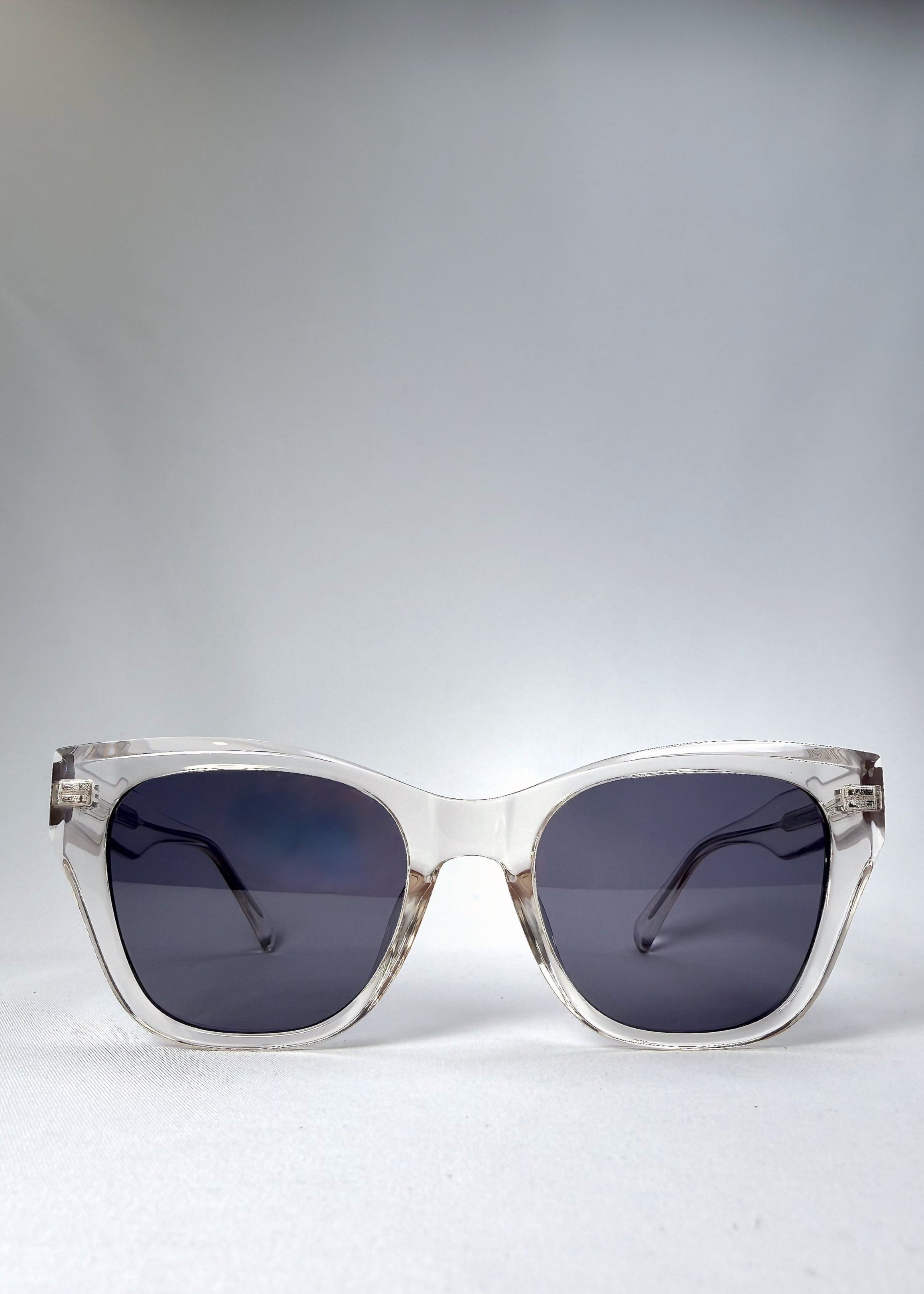 Front view of the Veyron sunglasses in Crystal Static, featuring a bold clear acetate frame with clean lines and slate-blue lenses.