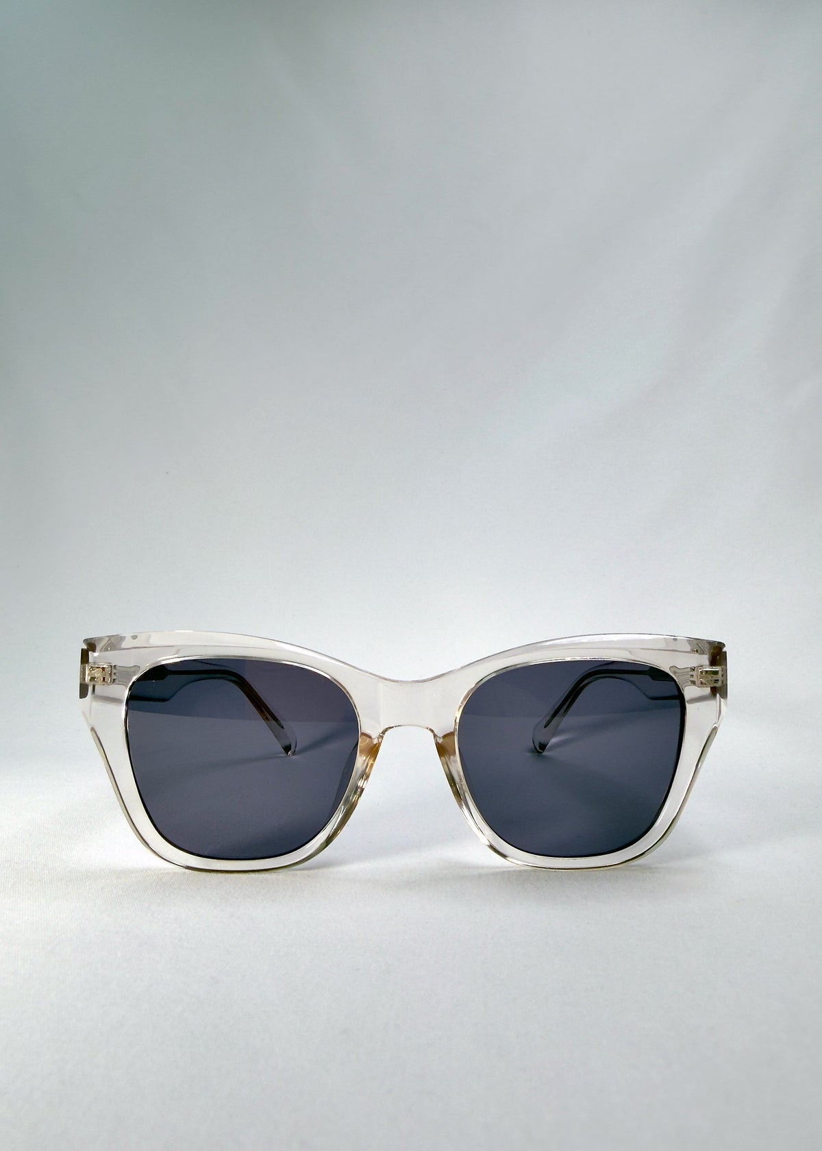 Front view of Veyron in Crystal Static, showing the clear acetate cat-eye frame and slate blue lenses.