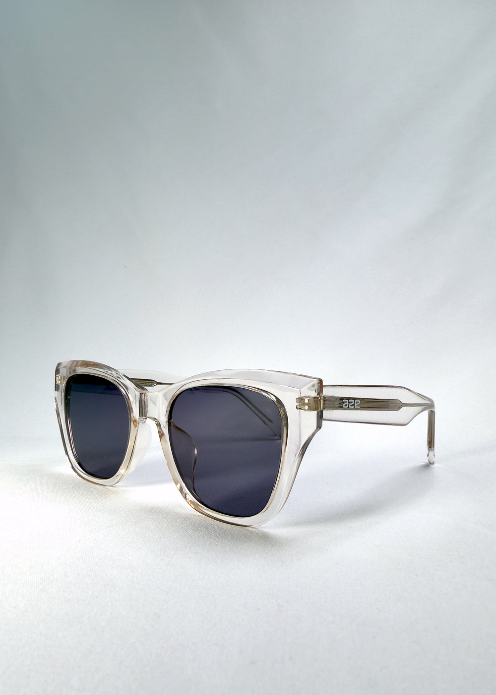 Left front-angle view of Veyron in Crystal Static, highlighting the clear acetate frame and sharp cat-eye silhouette.