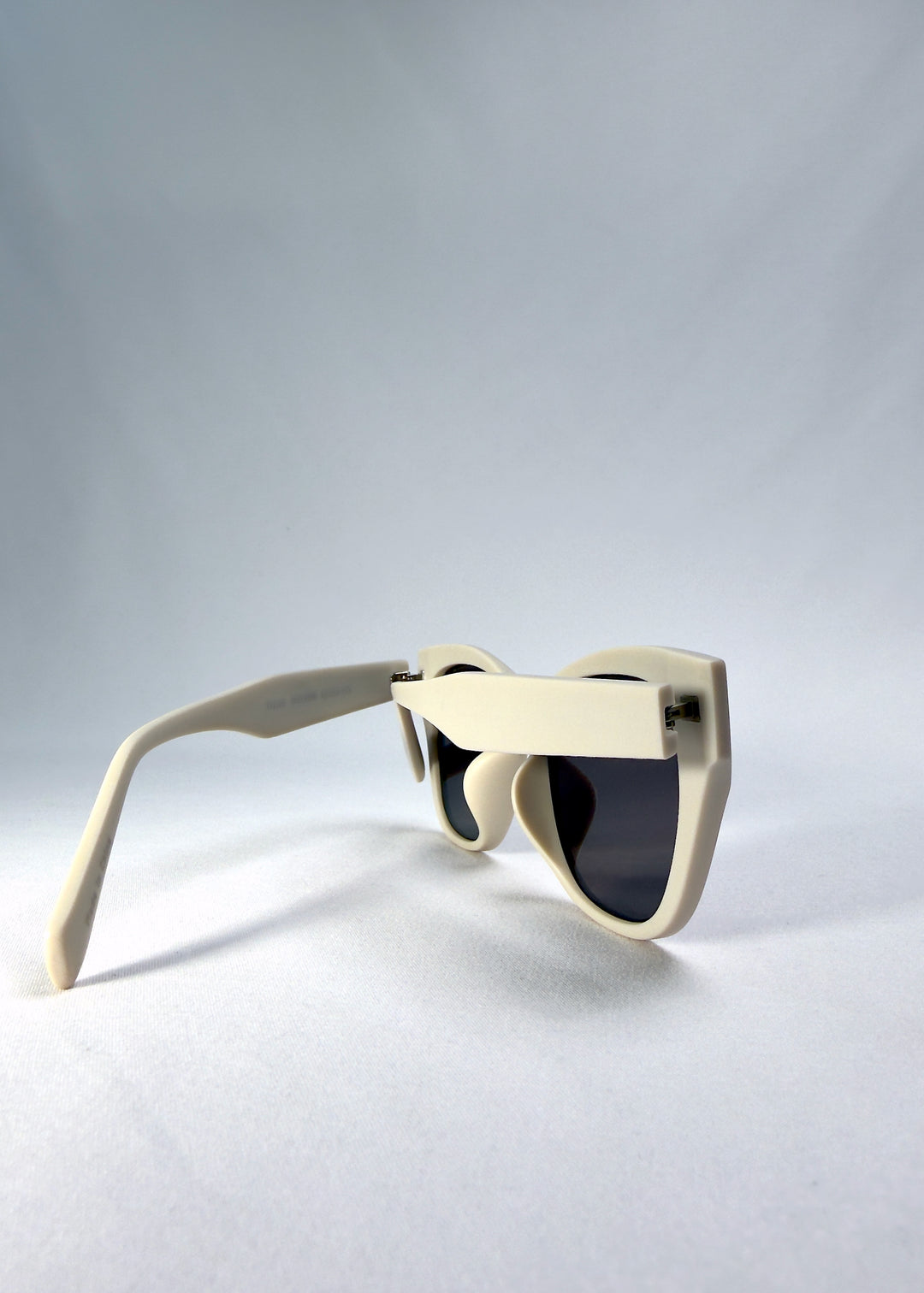 Left side-temple view of Veyron sunglasses in Pale Mirage showing matte ivory acetate frame and dark grey lenses.