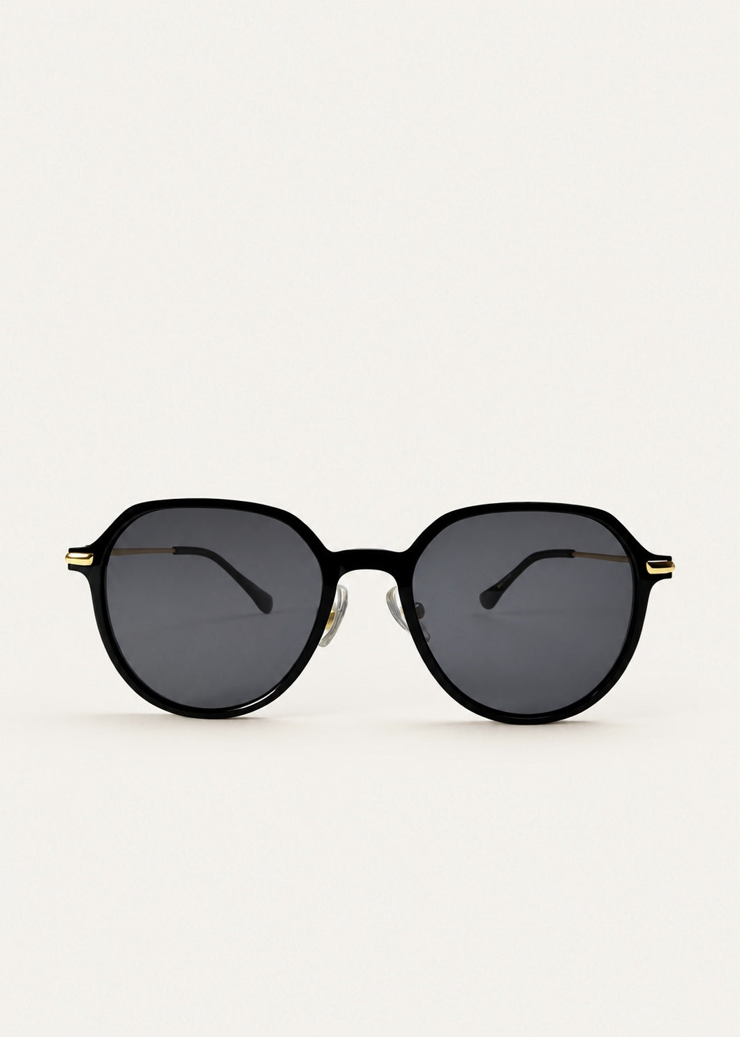 Front view of AZE Vireo Arc sunglasses in Duskgold, featuring a dark softly geometric frame, gold-tone accents, and smoky gray lenses, showing the full front silhouette.