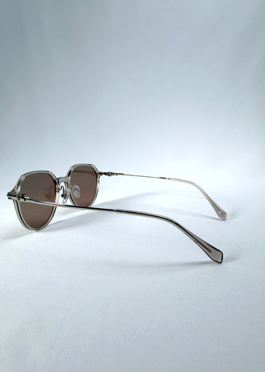 Back-angle view of AZE Vireo Arc sunglasses in Taupe Rosé, featuring a translucent taupe frame and rose-brown gradient lenses, showing the rear frame structure and temple alignment.