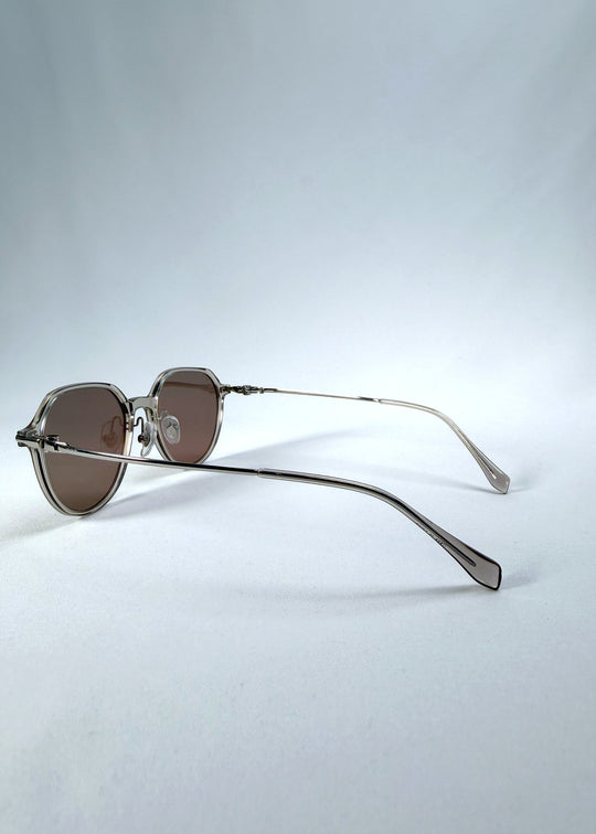 Back-angle view of AZE Vireo Arc sunglasses in Taupe Rosé, featuring a translucent taupe frame and rose-brown gradient lenses, showing the rear frame structure and temple alignment. 