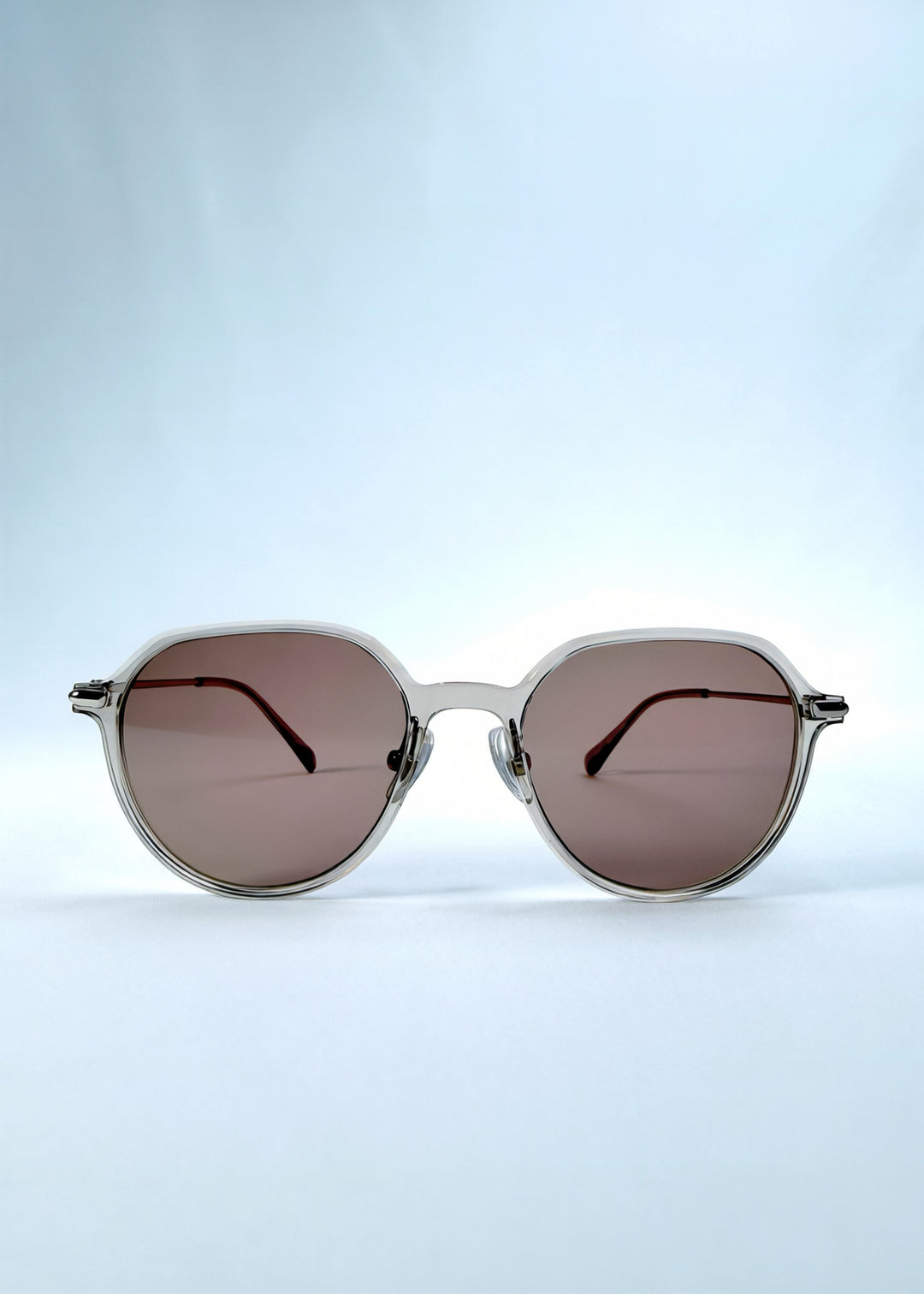 Front view of AZE Vireo Arc sunglasses in Taupe Rosé, featuring a translucent taupe frame and rose-brown gradient lenses, showing the full front silhouette.