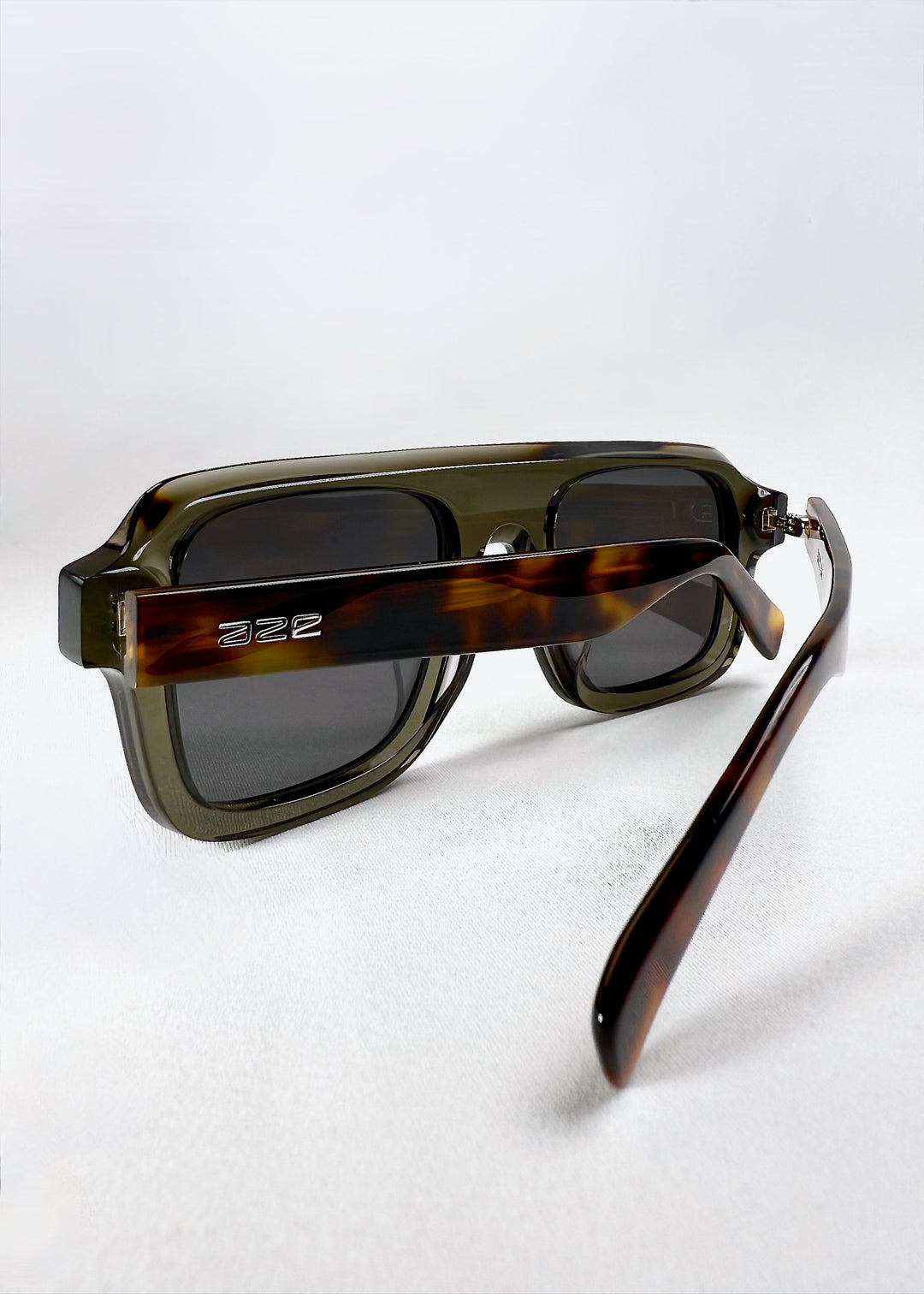 Vortex Edge in Ash Tortoise sunglasses, folded and viewed from the back, showing the contrast between smoky grey front and tortoiseshell-patterned arms. 