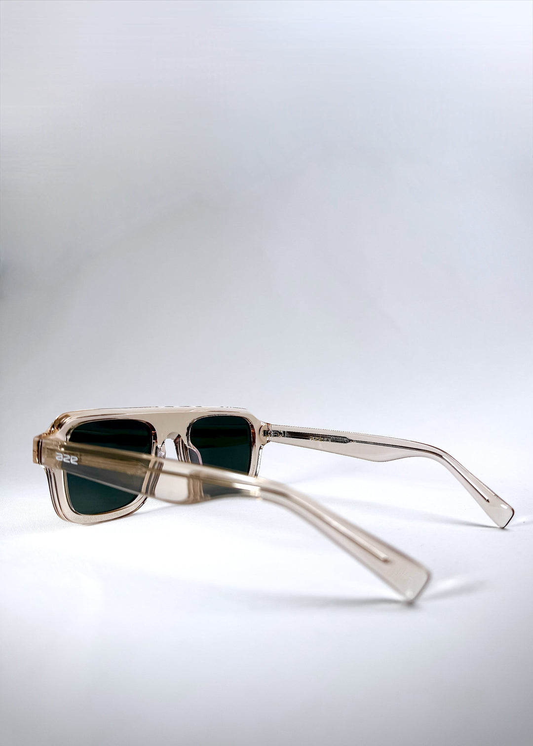 Side-angle view of Vortex Edge - Champagne Glow sunglasses highlighting the geometric design and warm champagne tones. 