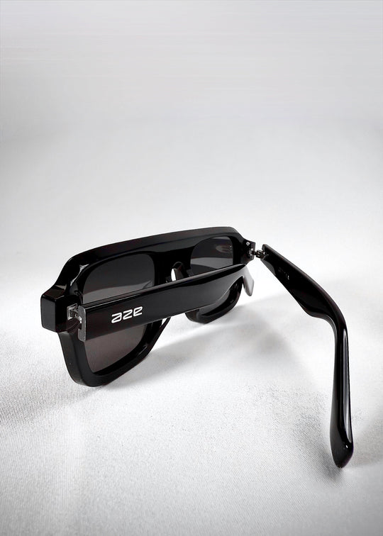 Close-up of folded Vortex Edge sunglasses in Obsidian Black, showcasing the glossy finish and hinge detailing. 