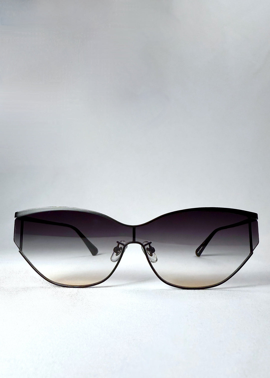 Front view of Zenith sunglasses in Midnight Eclipse, showing the semi-rimless shield silhouette and gradient lenses fading from charcoal to soft tea. 