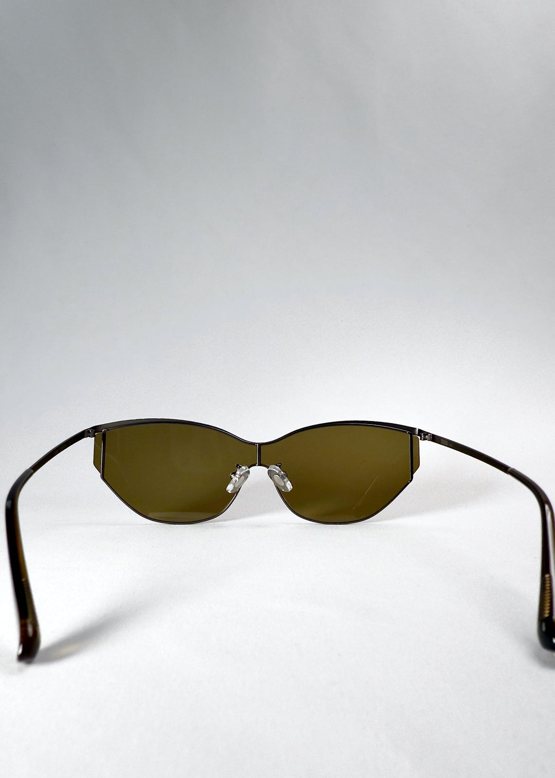 Back view of Zenith sunglasses in Olive Smoke, showing the inner lens curvature, adjustable nose pads and open temples. 