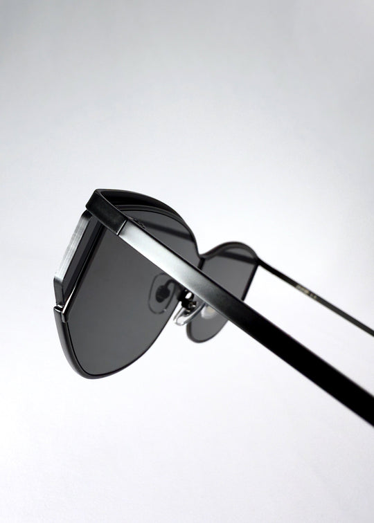 Angle detail of Zenith sunglasses in Onyx Black, highlighting the matte frame finish and shield lens edge. 